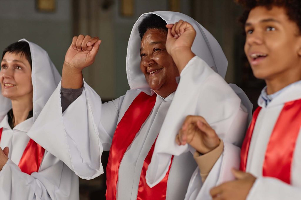 Group of happy people in white costumes singing together in church choir