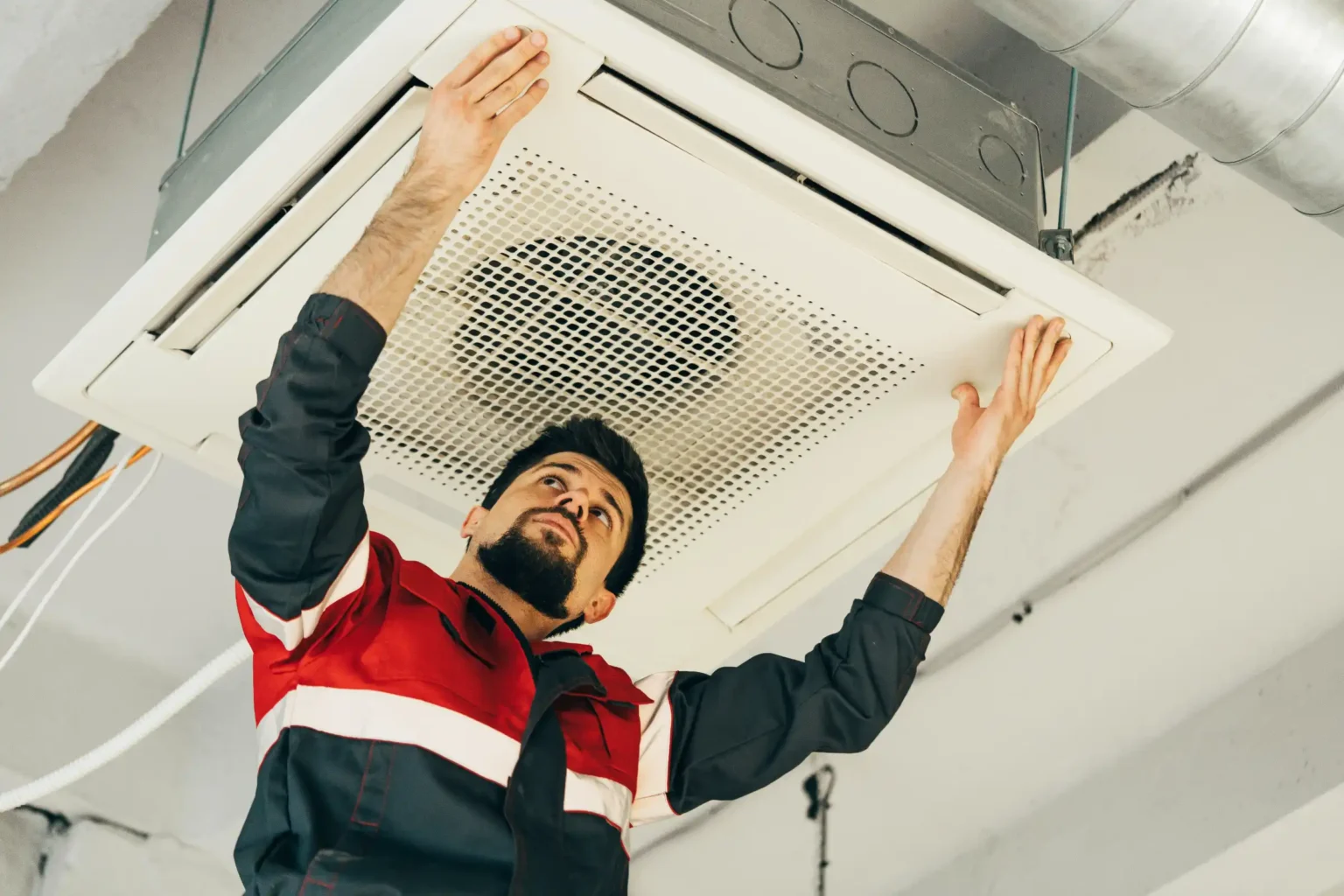 technician-installs-ceiling-air-conditioning-unit-GSAL9F9