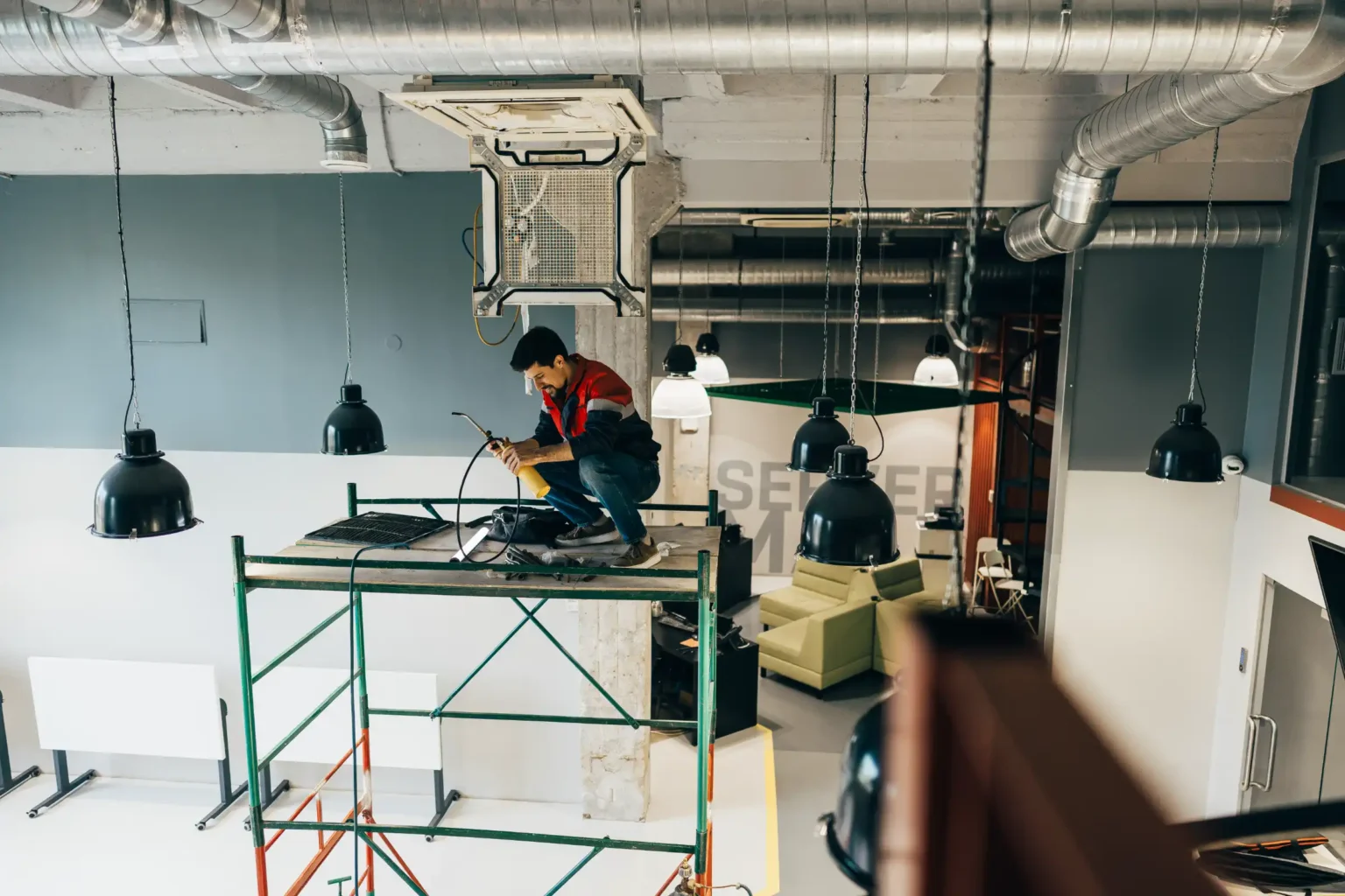 worker-performs-electrical-maintenance-on-scaffold-CFJWK3W