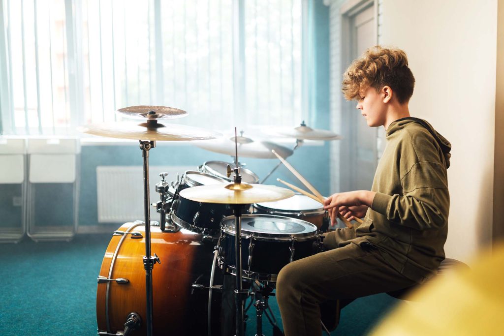 Teen boy musician behind a drum kit.