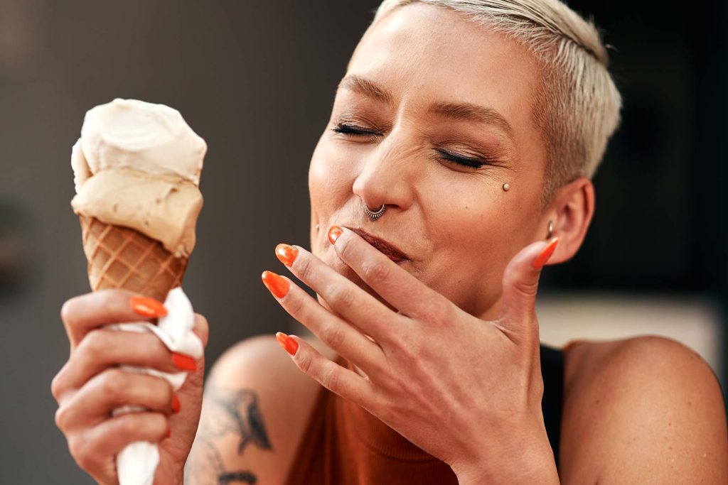 Cropped shot of a young woman enjoying a ice cream cone outdoors.