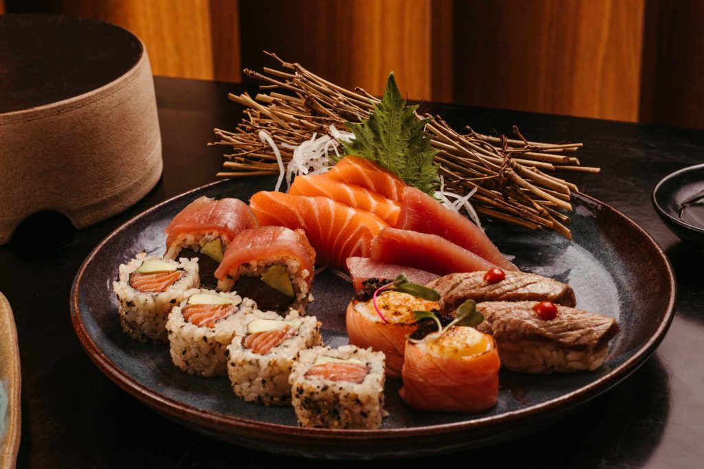 A close-up photo of a plate of freshly prepared sushi, displayed on a table