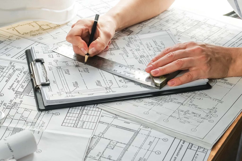 architect design working drawing sketch plans blueprints and making architectural construction model in home.