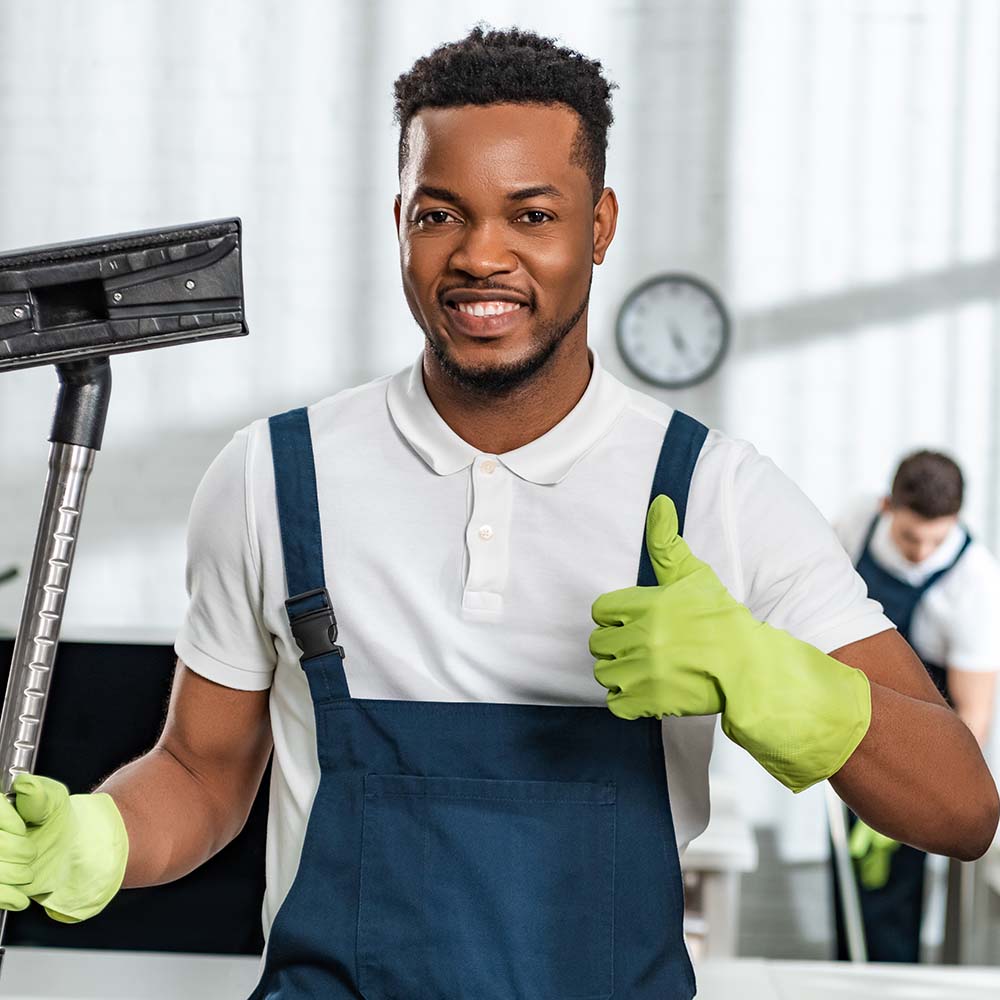 smiling-african-american-cleaner-holding-vacuum-cl3-Z9YUQND