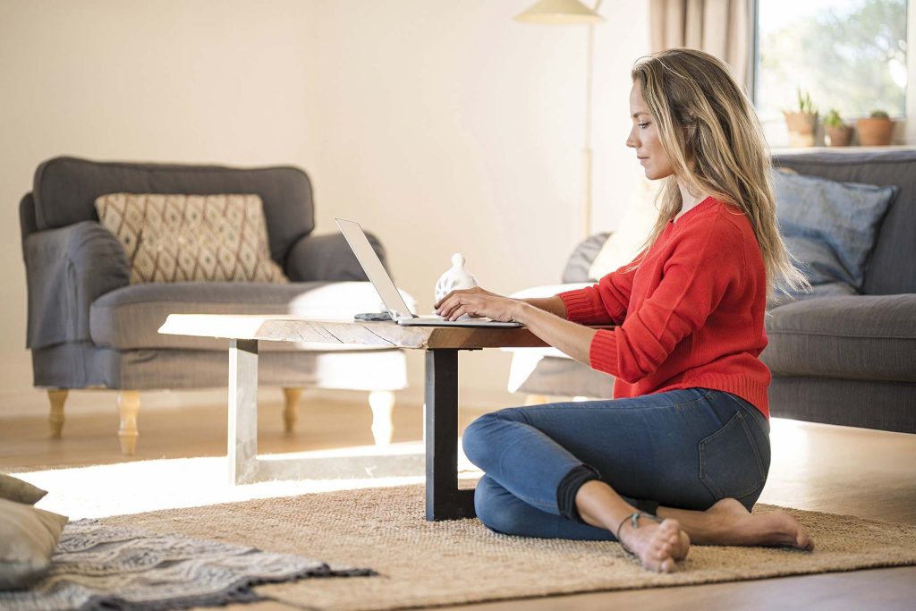 Woman using laptop on coffee table at home