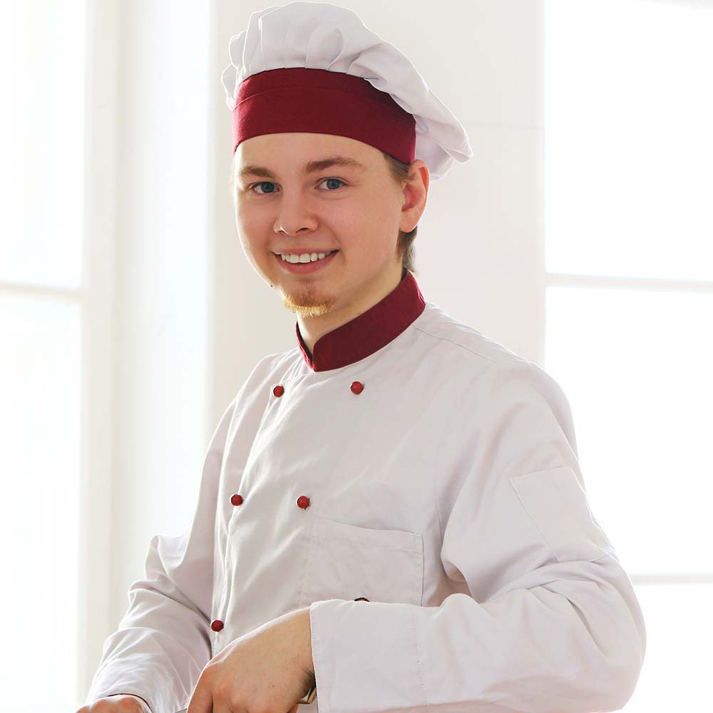 Young and cheerful chef on the kitchen