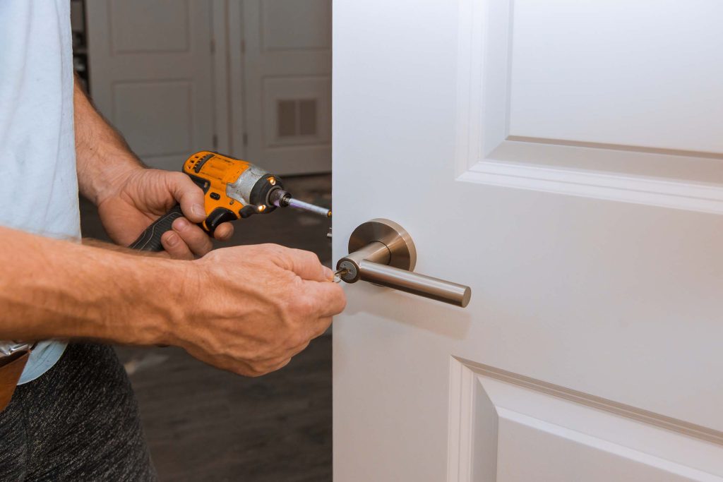 Installation of the door lock interior door woodworker hands install locked