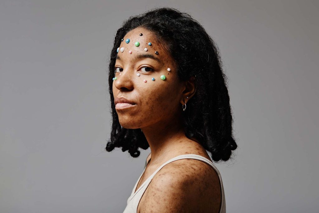 Minimal portrait of black young woman with no makeup and pearl beads as face decoration, copy space