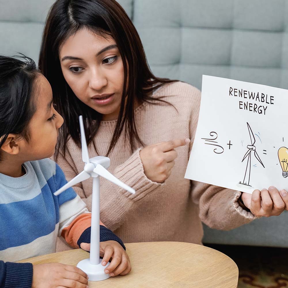 Asian mother working with her child on renewable energy project for school science class at home - Focus on mom right hand