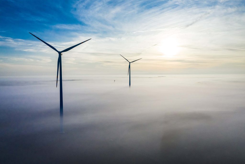 Wind turbines over fog. Wind farm in Poland. Renewable energy. Aerial view of autumn in Poland