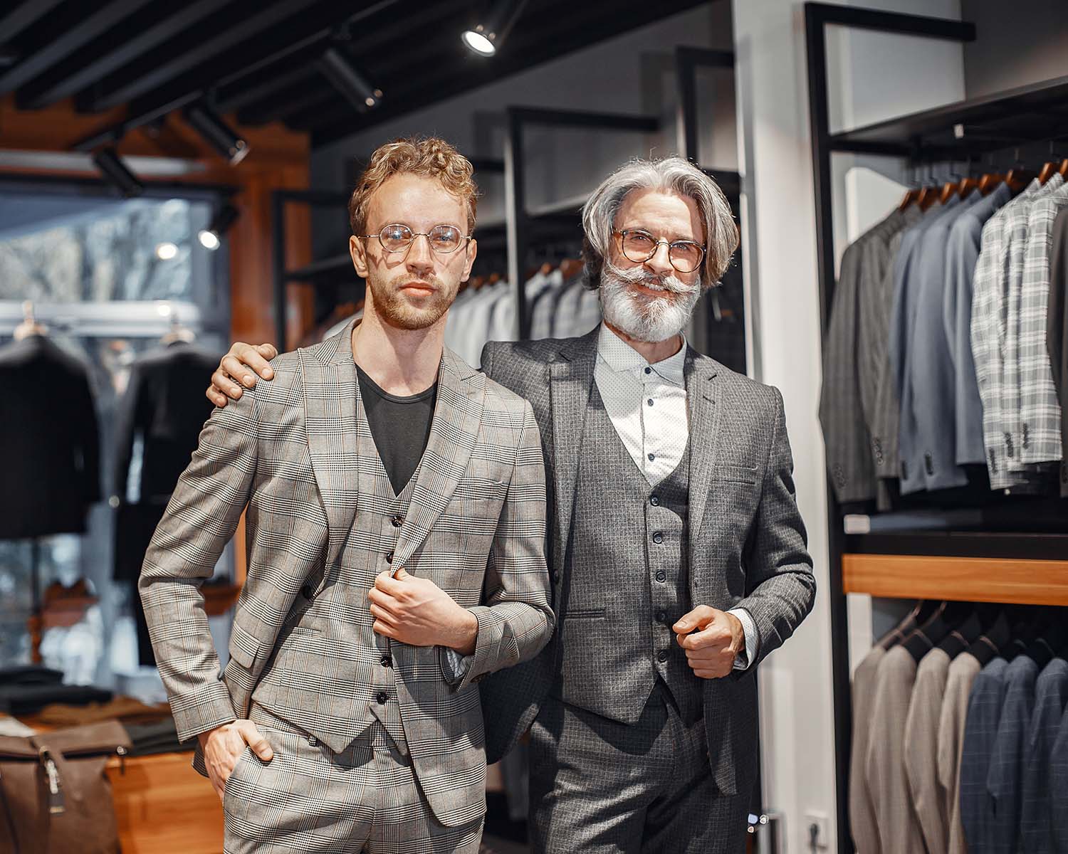 Portrait of a mature man. Assistant helps a costumer. Senior visiting a fashion boutique. Male buy a new exclusive costume.