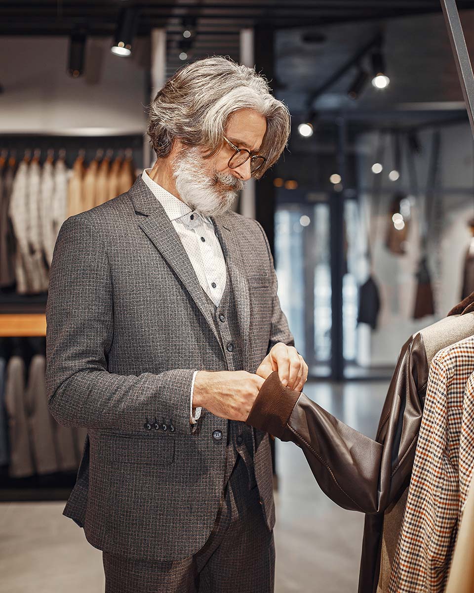 Portrait of a rich mature man. Senior visiting a fashion boutique. Male buy a new exclusive costume.