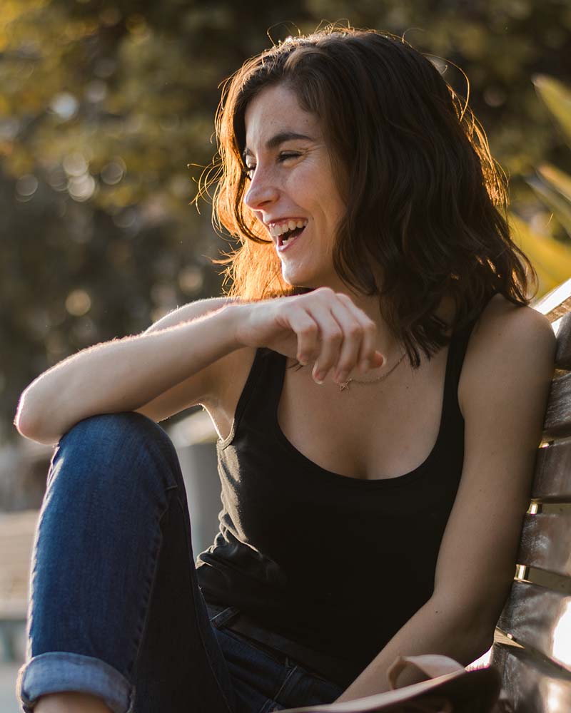Stock photo of a portrait of a young woman in a park of a city. Lifestyle, smiling