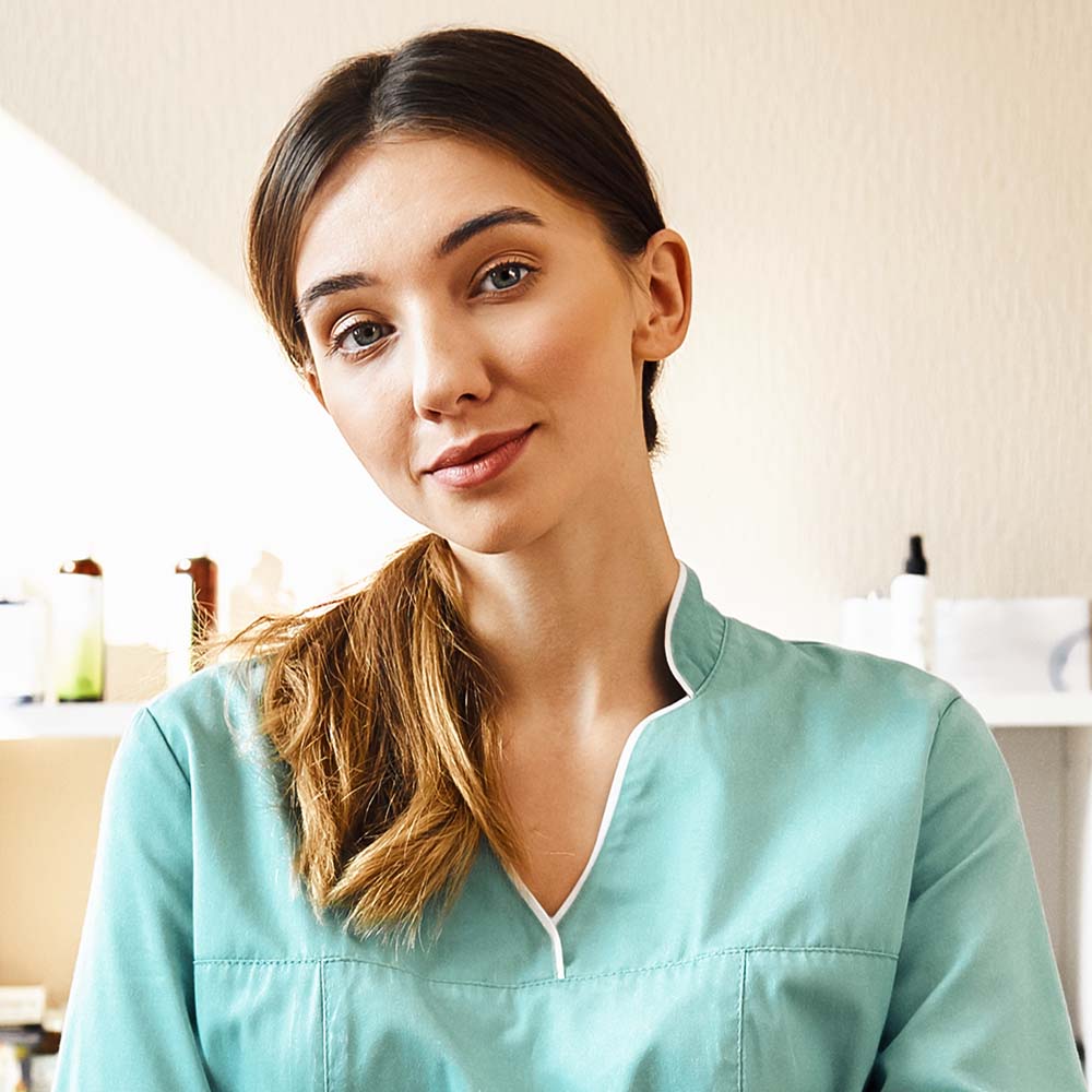 Professional doctor. Portrait of kind and young female veterinarian in work uniform standing with arms crossed in veterinary clinic. Pet care concept. Medicine concept. Animal hospital