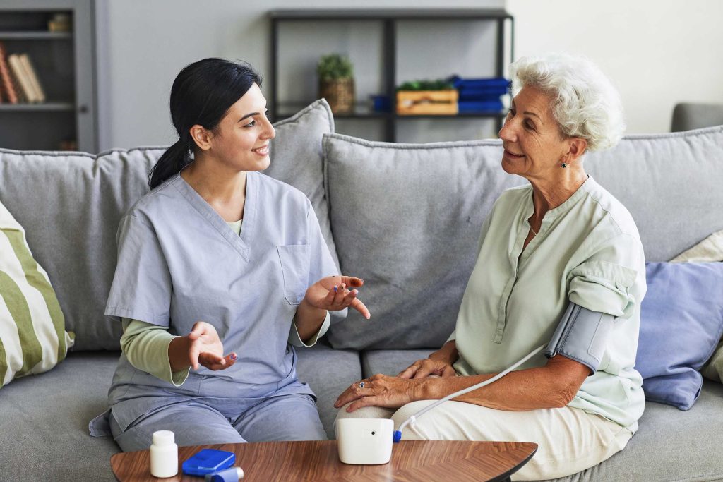 Portrait of smiling senior woman talking to female nurse in retirement home, copy space