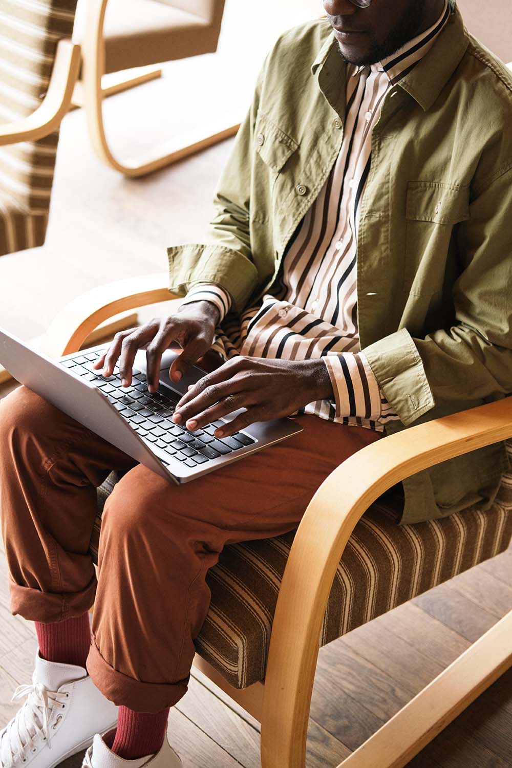 African young man sitting on chair and typing on laptop computer he working online at office